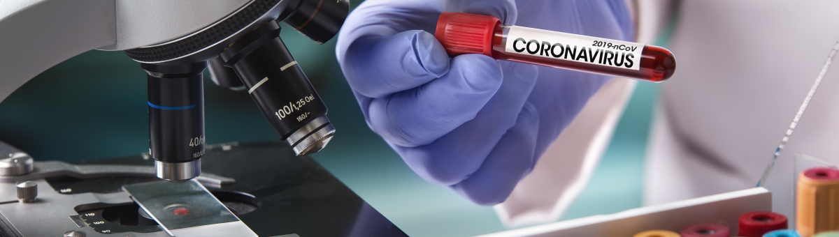 a hand holding vial, the vial is labelled 'coronavirus'